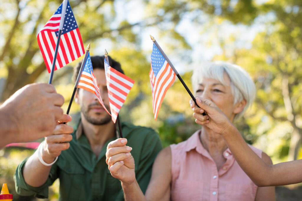 Family holding american flags in the park on a sunny day